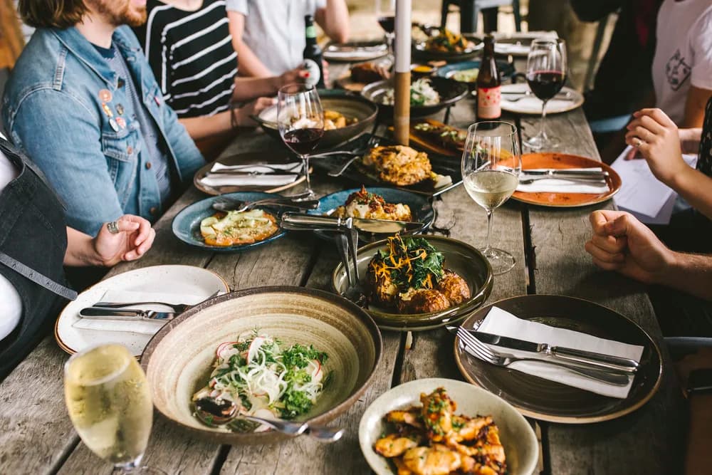 A long table set family style with bowls, boards, and wine