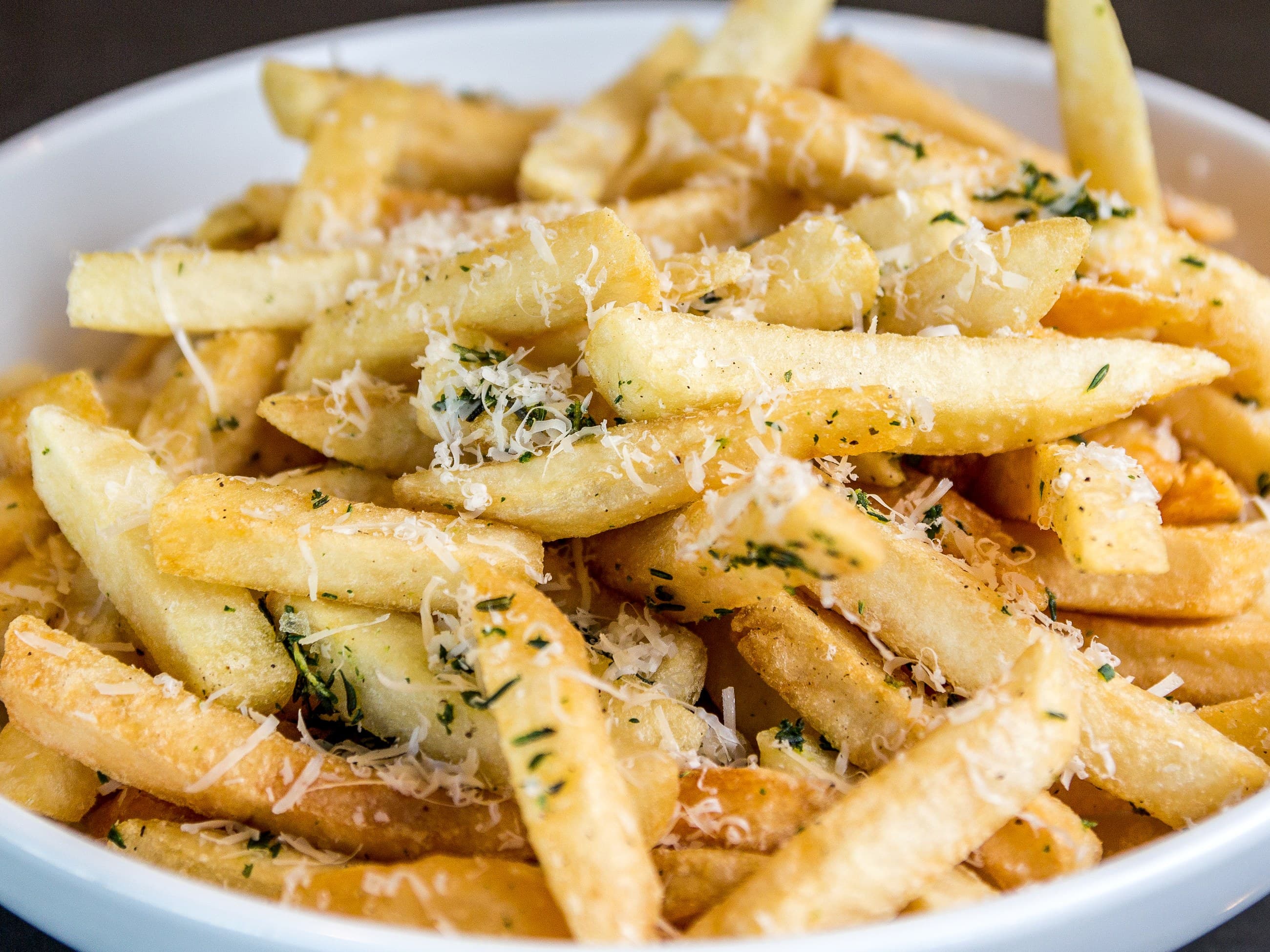 Parmesan herb fries in a bowl, close up