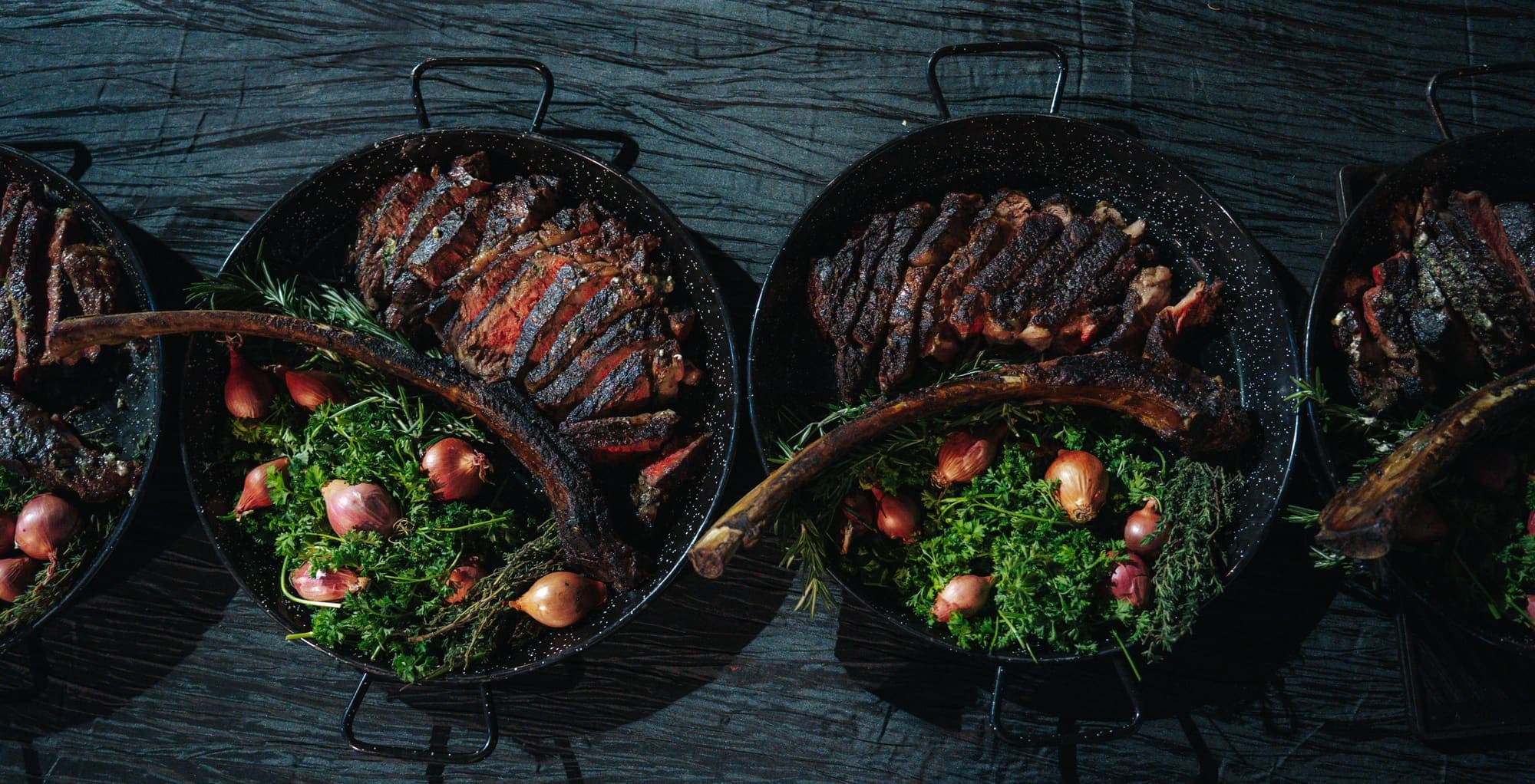 Cast-iron pans of ribs, greens, and roasted vegetables fresh off the fire